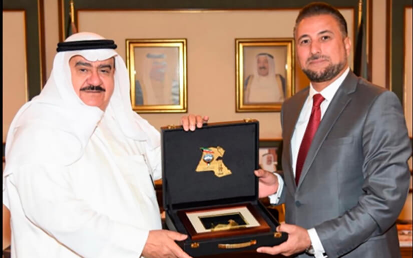 Compañero Mohamed Lashtar recibe del gobernador del departamento de Jahra General (r) Fahed Ahmed Al-Amir un recuerdo, el símbolo del departamento